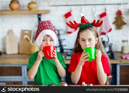 Good morning. Brother and sister drink tea at the kitchen table with cookies in the kitchen. A time of miracles and fulfillment of desires. Merry Christmas.. Good morning. Brother and sister drink tea at the kitchen table with cookies in the kitchen. A time of miracles and fulfillment of desires.