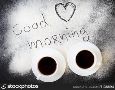 good morning inscription on the board with flour and two mugs of coffee. valentine card. good morning inscription on the board with flour and two mugs of coffee