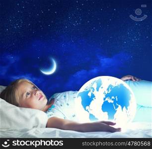 Good night. Girl in bed with Earth planet in hands