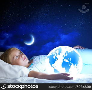 Good night. Girl in bed with Earth planet in hands. Elements of this image are furnished by NASA