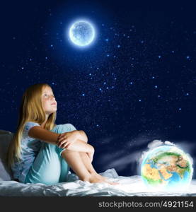 Good night. Girl sitting in bed and dreaming. Elements of this image are furnished by NASA