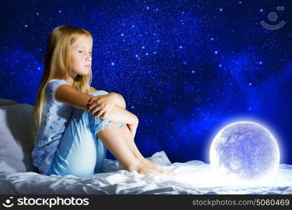 Good night. Girl sitting in bed with moon in hands