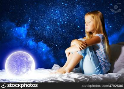 Good night. Girl sitting in her bed and dreaming