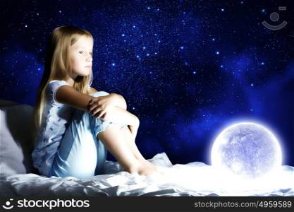 Good night. Girl sitting in her bed and dreaming