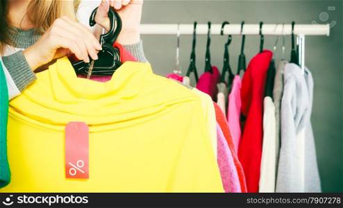 Good shopping sale concept. woman choosing clothes holding discount red label with percent sign in hand