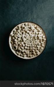 Good vibes and dream and inspiration concept shot, white dices over a cup , dark moody tones, lifestyle selective focus
