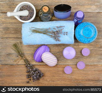 Goods for spa: soap, sea salt, towel, oil of lavender on wooden table. top view