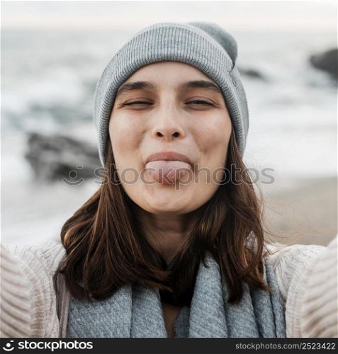 goofy woman taking selfie beach