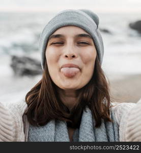 goofy woman taking selfie beach