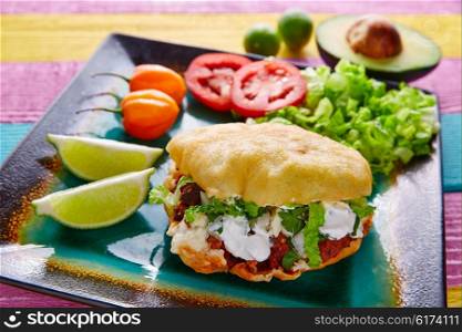 Gordita mexican fried puff corn taco filled with pastor meat lettuce and cream