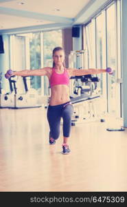 Gorgeou woman girl lifting some weights and working on her biceps in a gym. lifting some weights and working on her biceps in a gym