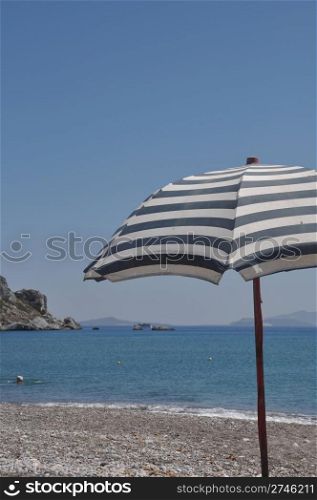 gorgeous beach scene with greek umbrella at Kefalos beach (Kos), Greece