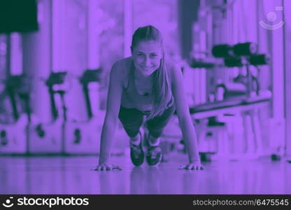 Gorgeous blonde woman warming up and doing some push ups a the gym duo tone. warming up and doing some push ups a the gym