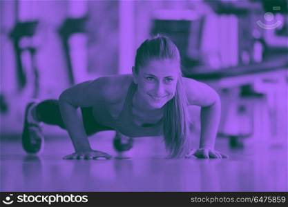 Gorgeous blonde woman warming up and doing some push ups a the gym duo tone. warming up and doing some push ups a the gym