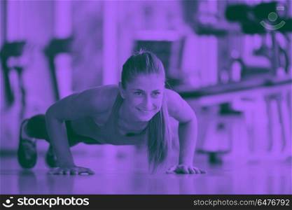 Gorgeous blonde woman warming up and doing some push ups a the gym duo tone. warming up and doing some push ups a the gym