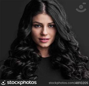 Gorgeous brunette with curly hair. Portrait of gorgeous brunette with curly long hair