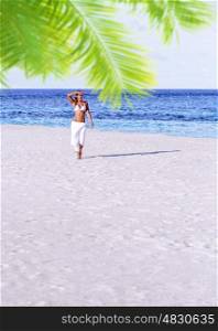Gorgeous female having fun on the beach, walking on sandy seashore, spending summer holidays on Maldives island, travel and tourism concept