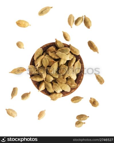 gorgeous green cardamom pods on a small vintage wooden plate (isolated on white background)