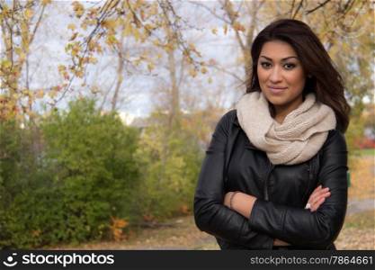 Gorgeous Hispanic woman posing with arms cross outside during autumn