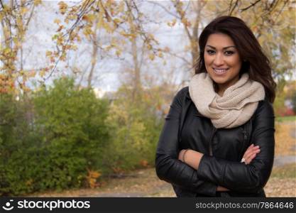 Gorgeous Hispanic woman posing with arms cross outside during fall