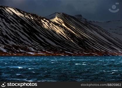 Gorgeous Landscape of a Snow-capped Mountains behind the River. Winter Cold Weather. Amazing Nature of Iceland.