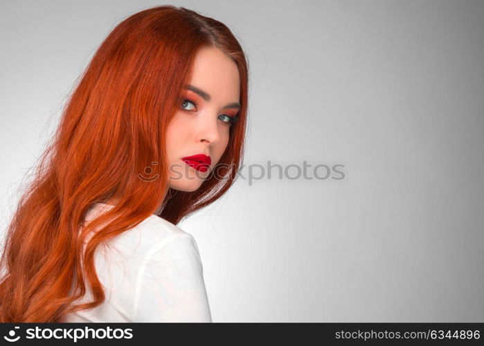 Gorgeous redhead girl. Gorgeous redhead girl with wavy hair beauty studio portrait