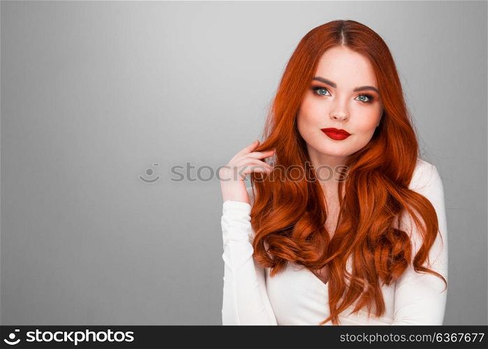 Gorgeous redhead girl. Gorgeous redhead girl with wavy hair beauty studio portrait