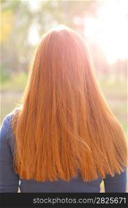 Gorgeous redhead girls hair from back. Outdoors, backlit