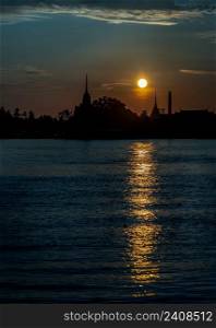Gorgeous scenic of Thai temple silhouettes along Chao phraya river over sun at sunrise. Travel attraction in Thailand, Space for text, No focus, specifically.