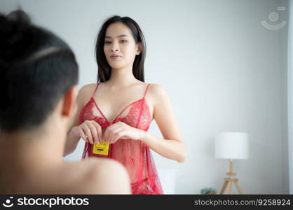 Gorgeous sexy couple enjoying sex in the house’s bedroom, Safe sex concept, couples with condoms.