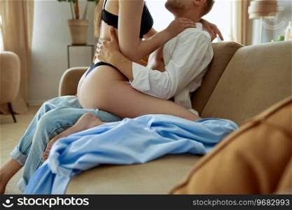 Gorgeous sexy couple enjoying sex on sofa at home living room closeup view. Emotional loving relationships and passion concept. Gorgeous sexy couple enjoying sex on sofa closeup view