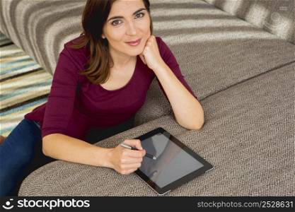 Gorgeous woman at home working with a tablet