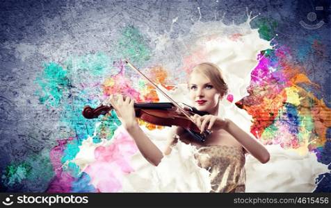 Gorgeous woman playing on violin. Image of beautiful female violinist playing against splashes background