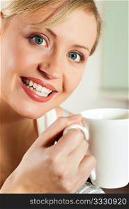 Gorgeous woman visibly enjoying a hot cup of coffee in the morning