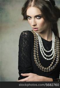 gorgeous woman wearing like a antique dame in charming pose with vintage hair-style and very precious jewellery