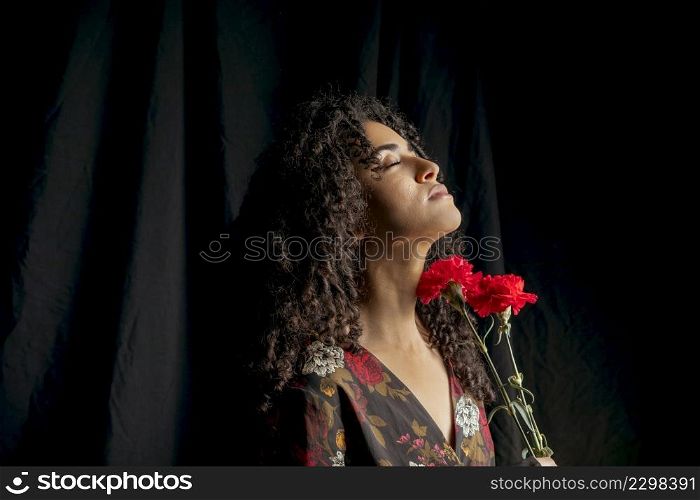gorgeous woman with red blooms darkness