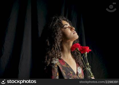 gorgeous woman with red blooms darkness