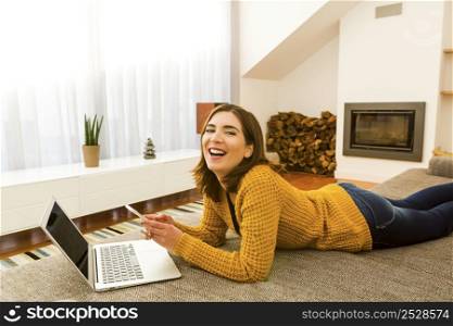Gorgeous young woman at home texting and laughing