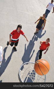 gorup of young boys who playing basketball outdoor on street with long shadows and bird view perspective