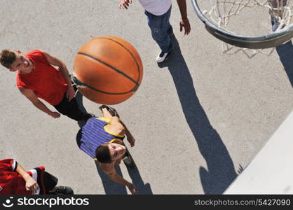 gorup of young boys who playing basketball outdoor on street with long shadows and bird view perspective