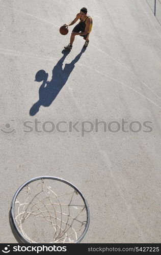 gorup of young boys who playing basketball outdoor on street with long shadows and bird view perspective