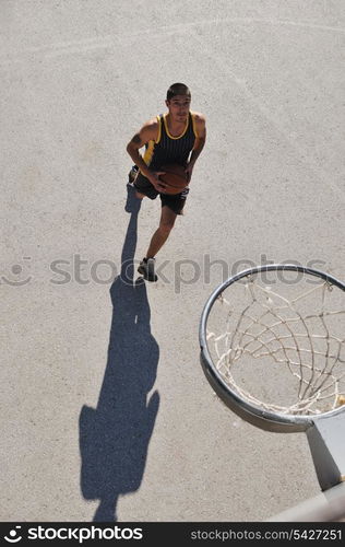 gorup of young boys who playing basketball outdoor on street with long shadows and bird view perspective