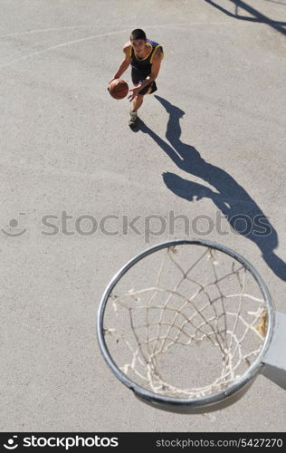 gorup of young boys who playing basketball outdoor on street with long shadows and bird view perspective