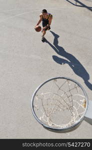 gorup of young boys who playing basketball outdoor on street with long shadows and bird view perspective