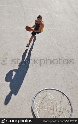 gorup of young boys who playing basketball outdoor on street with long shadows and bird view perspective