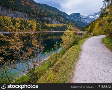 Gosauseen or Vorderer Gosausee lake, Upper Austria. Colorful autumn alpine view of mountain lake with clear transparent water and reflections. Dachstein summit and glacier in far.