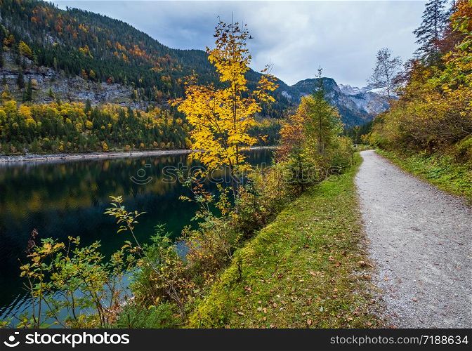 Gosauseen or Vorderer Gosausee lake, Upper Austria. Colorful autumn alpine view of mountain lake with clear transparent water and reflections. Dachstein summit and glacier in far.