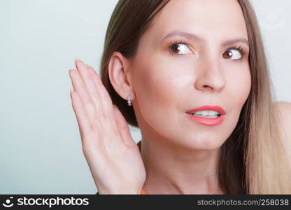 Gossip girl eavesdropping with hand to ear. Woman overhearing listening to rumors. Spying and secret concept.. Gossip girl eavesdropping with hand to ear.