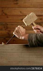 gouge wood chisel carpenter tool hammer in hand working wooden background