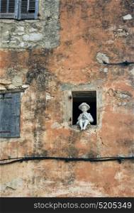GOURDON, FRANCE - OCTOBER 31, 2014: A figurine in the window of an old house
